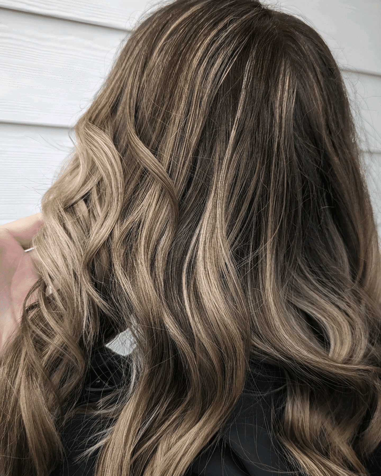 Wavy brown hair with blonde highlights cascading over shoulders.