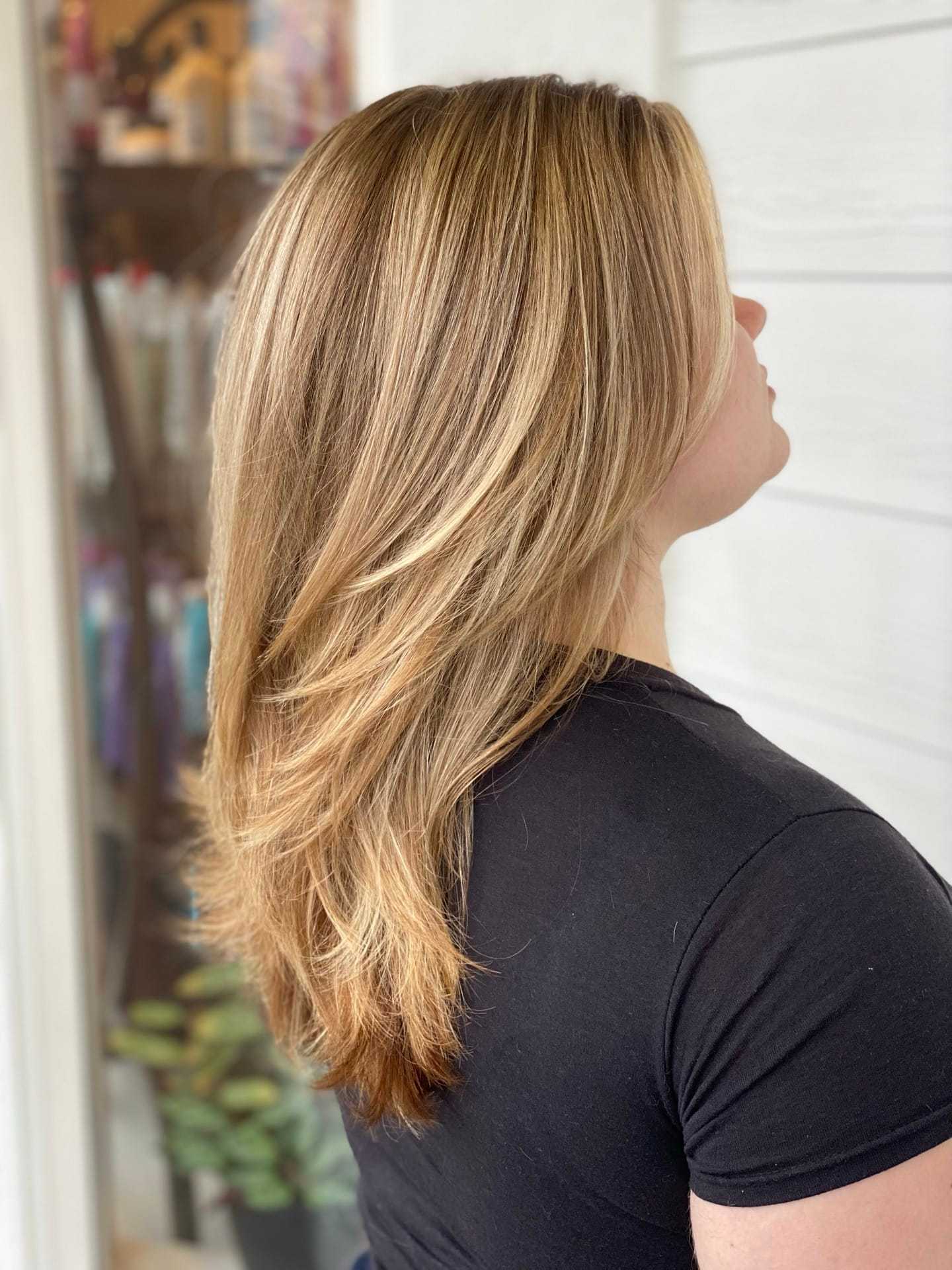 Blonde-haired person with layered hairstyle, facing slightly away from the camera.