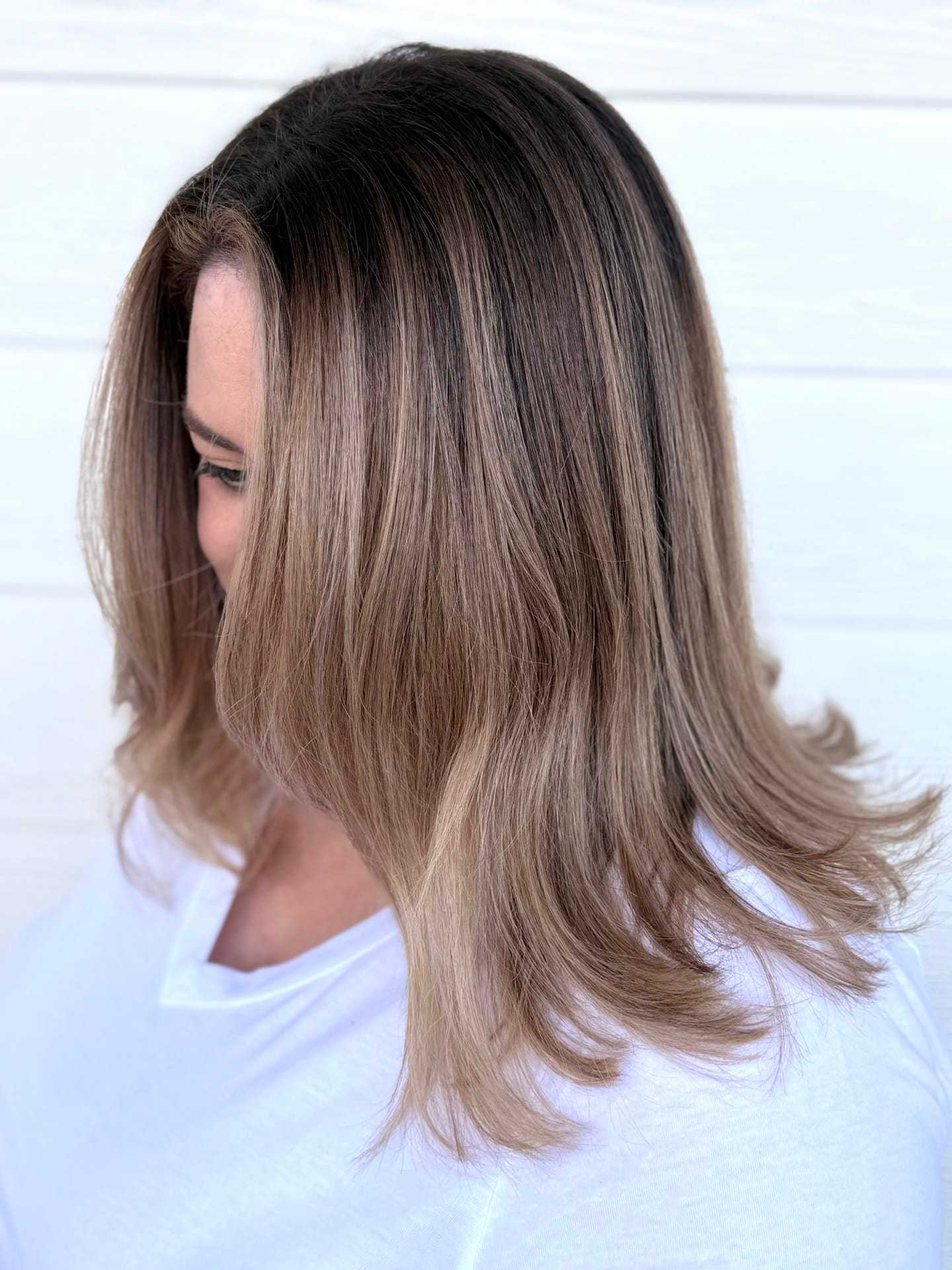 Short hair with a smooth brown and blonde balayage against a white background.